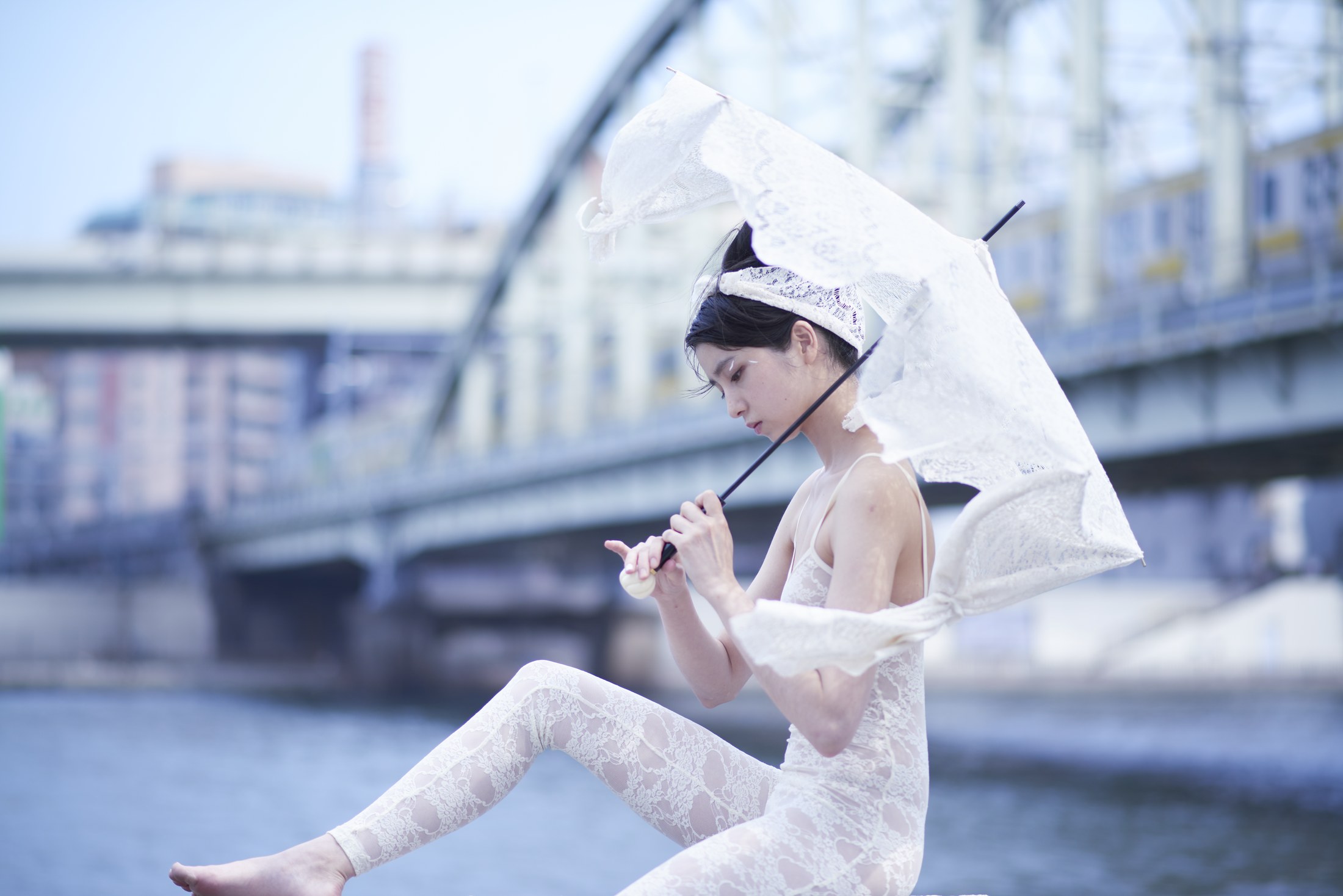 湖畔で傘を持つ女性